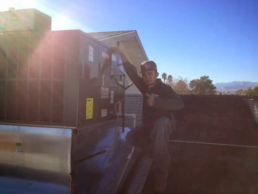 HVAC technician performing HVAC Inspection on a rooftop unit in Tyler